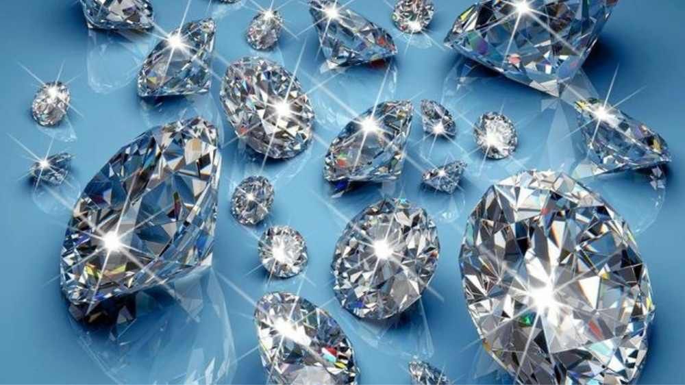Big and small natural diamonds shown scattered on blue paper