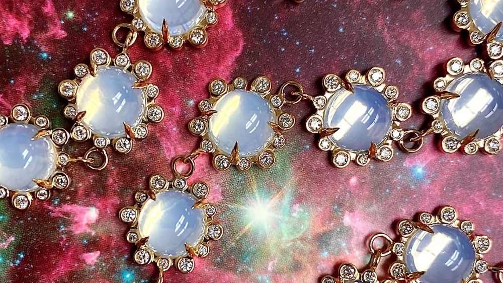 cross section of moon quartz necklace with diamonds on a cosmic star background