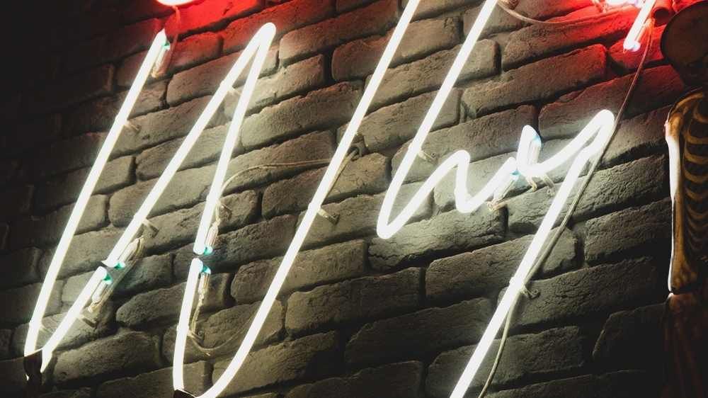 Electric sign that says why in cursive